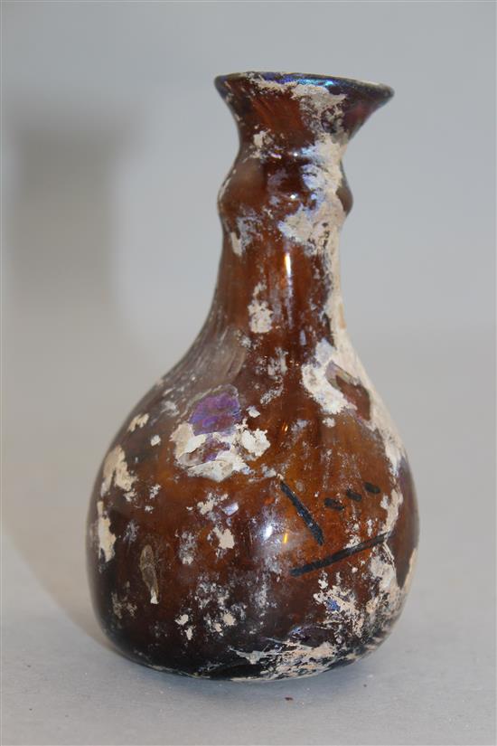 A Roman amber glass flask, c.2nd century AD, 11cm